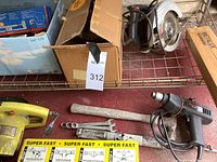 Top-down view showing the Black & Decker corded drill, 7 1/2 inch Skil saw in yellow, set of wrenches, and a small motor or similar device.
