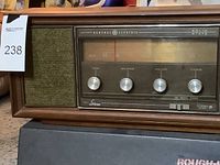 Front view of the vintage General Electric radio showing frequency display, control knobs, and speaker grille on the left side.