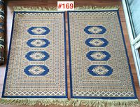 Both carpets laid side by side on hardwood floor showing full patterns and matching design