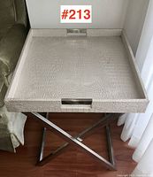 Front view of the occasional table showing the tray top with faux crocodile pattern and the metal base.