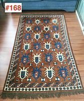 Full view of the hand knotted carpet showing overall pattern, colors and fringes