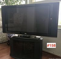 Front view of LG plasma TV on Sony TV stand with remote on top, showing size and condition.