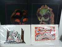Two Jim Gilbert prints showing Native Heritage Centre masks on dark backgrounds.
