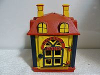 Front view of cast iron towing bank shaped like a house with 'Towing Bank' on the door.