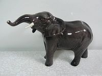 Front and side views of the Good Sized Beswick Elephant Figurine in excellent condition showing details of the raised trunk and tusks.