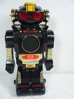 Front view of the black robot toy with red eyes, gold and red details, and '2002' printed on the chest.