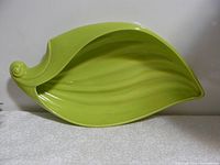 Top view of the green leaf-shaped ceramic dish showing its veined texture and curled end tip.
