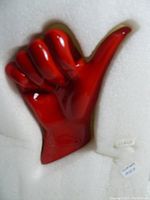 Red ceramic hand-shaped wall hook from front showing thumbs-up shape