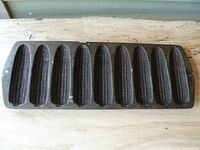 Top view showing 9 corn-shaped molds in cast iron pan with detailed corn kernels.