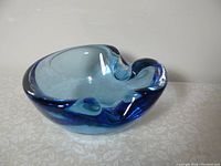 Photo of blue Venetian Murano glass dish, showing organic curved shape and color gradation