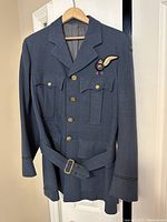 Front view of RCAF blue-grey wool uniform jacket with buttons, pockets, insignia, and belt.