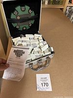 Open aluminum case showing domino tiles and instruction sheet with label Ma Sold Lot 170