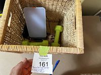 Thera Lite therapy lamp and two 5 lb weights inside a wicker basket with auction tag