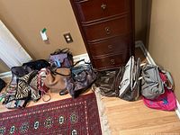 Wide view of the handbags arranged on the floor showing various styles, colors, and patterns of the bags included
