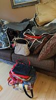 Couch with multiple handbags displayed, various styles and colors
