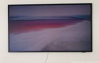 Front view of Samsung The Frame TV mounted on wall displaying gradient image