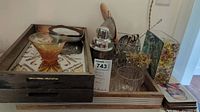 Wide view of the wooden tray filled with the cocktail shaker, ice bucket, glasses, vase, skewers, amber bowl, and coasters.