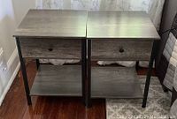 Pair of side tables side by side showing front view with drawer and shelf.
