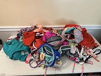 Photo showing a pile of mixed bikini tops and bottoms in various colors and prints spread on a table.