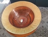 Top view of amber glass bowl sitting inside matching plate, showing the wide rim and smooth bowl interior