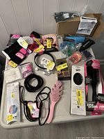 Overview of all hair care products and accessories on table, showing brushes, elastics, trimmer in packaging, and other items.