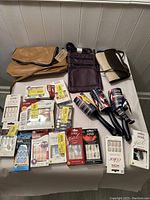 Lot of 15+ items showing nail kits, small bags, and lint rollers arranged on a table.