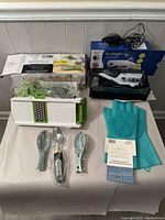 Grouped view of all items showing mandolin slicer, ice cream scoop, sewing machine in box, dishwashing gloves, fish scale removers, and scoops.