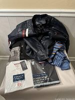 All 5 clothing items shown including black leather motorbike jacket, gray and black shirt, knitted blue cardigan, and two sealed French Toast uniform tops.