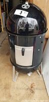 Front view of assembled smoker showing domed lid, body and legs
