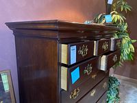 Side angle view showing dresser with three upper drawers partially open, dark wood finish, and brass handles.