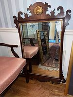 Full front view of mirror leaning against wall showing overall frame and reflection.