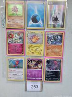 Nine Pokémon holographic cards including Pokémon, energy and trainer items, displayed in a 3x3 layout.