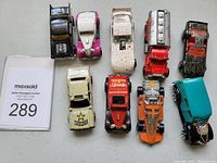 Photo of 9 vintage Hot Wheels die cast cars arranged in two rows showing top and front views.