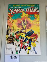 Front cover of The Uncanny X-Men and The New Teen Titans #1 comic book showing multiple superhero characters with a vivid colored background.