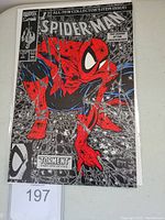 Front cover showing Spider-Man in red, black, and silver variant cover design with webs and text details.