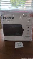 Photo showing a packaged PureFit cranberry sofa slipcover with product image and features.