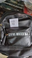 Front view of black leather Steve Madden backpack with visible branding and front pocket.