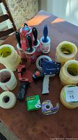 Photo showing the handheld tape dispenser, large packaging tape rolls, small Scotch tape dispensers, and lint rollers.