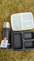 Photo of a black Thermos brand thermos with stainless steel cup, a black three-compartment plastic lunch container, and a white three-compartment plastic lunch container.