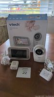 Front view of Vtech video monitor set with camera, display screen, power cords, and box
