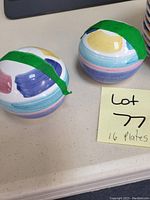 Two round ceramic salad plates with green painter's tape around the edge, featuring pastel stripe patterns.