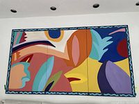 Three-section contemporary wall art with vibrant abstract shapes and colors mounted on a white wall.