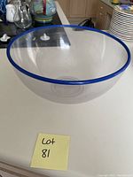Single large clear glass bowl with blue rim shown on countertop.