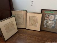 Four framed portrait prints displayed on floor, three pencil/pastel sketches of faces and one lithograph print signed Boulanger