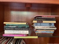 Photo of a selection of nonfiction books on a wooden shelf, showing titles related to art, gardening, and photography.