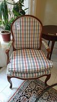 Full view of wood frame chair with checkered plaid upholstery on seat, back, and arms.