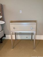 Front view of Lois Macaulay end table showing drawer and metal legs.