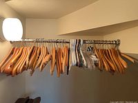 Closet rod with wooden, plastic, and clear plastic clip clothes hangers hanging