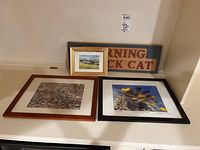 Four pieces including 3 framed photos/art and one wooden sign, displayed on a white shelf.