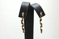 Front view showing both 10K gold spiral earrings hanging on display stand.